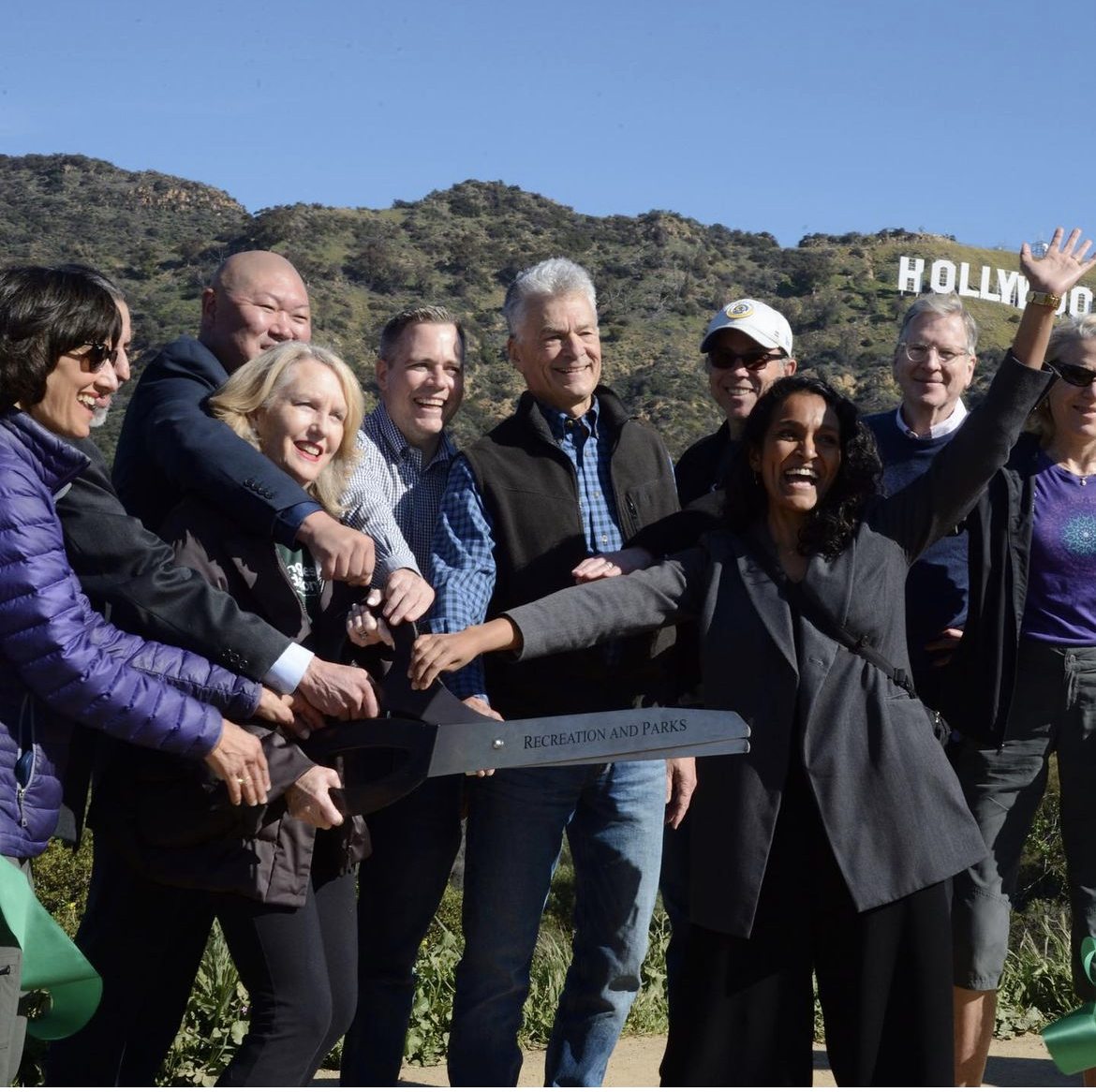 Nithya Raman cutting ribbon near Hollywood Sign