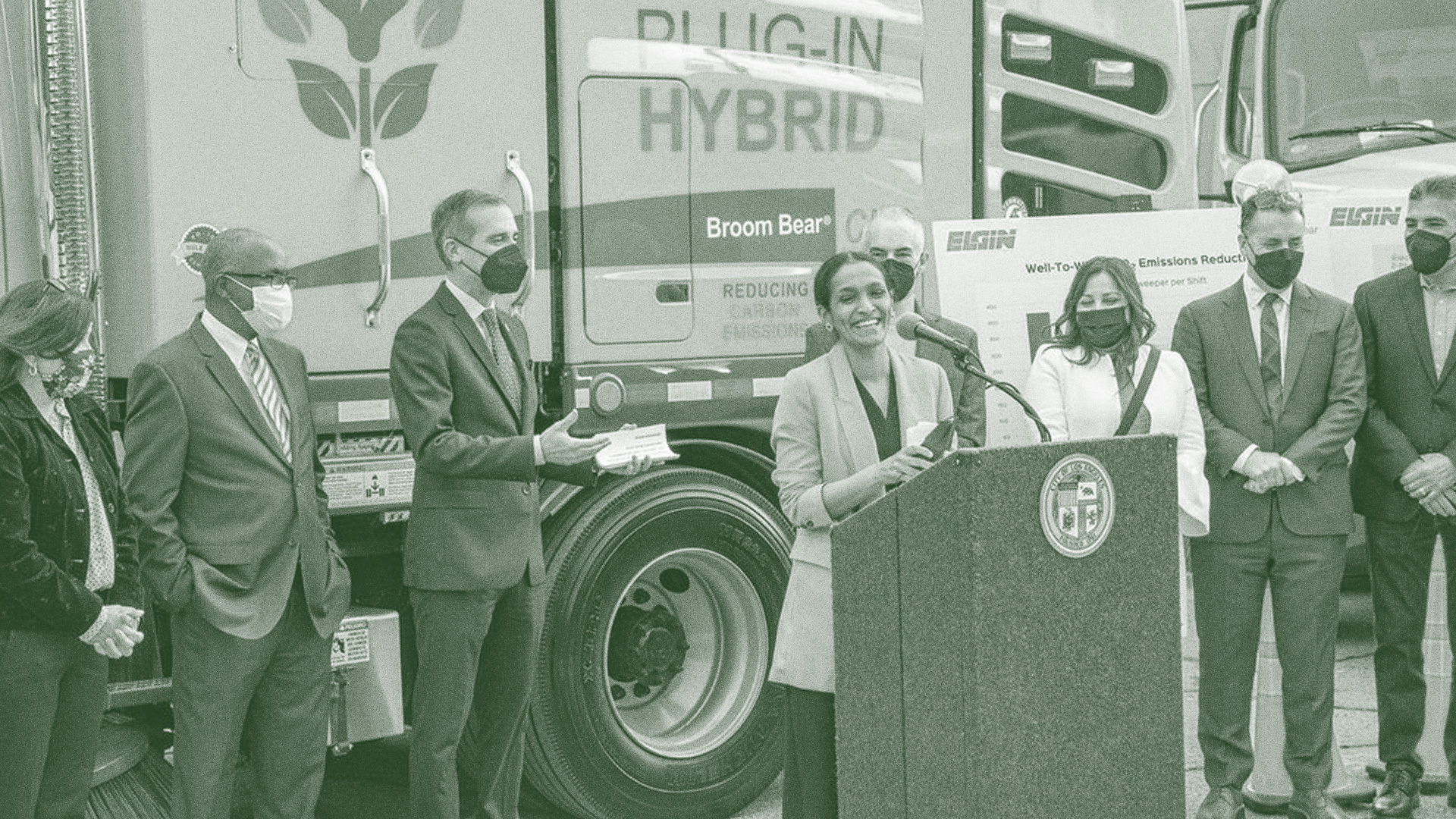 Nithya Raman making speech with plug-in hybrid truck in background