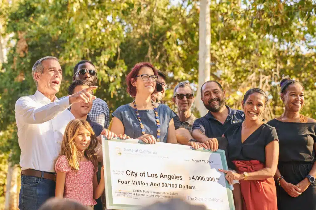 group of people around a 4 million dollar check including former LA mayor eric garcetti and cd4 councilmember nithya raman